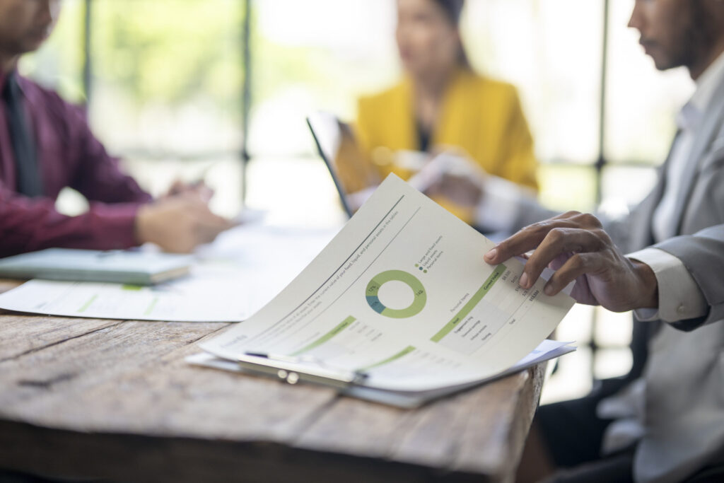 a man is pointing at a pie chart on a table in fro 2025 10 01 01 05 22 utc scaled.jpg